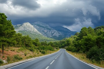 Fototapeta premium Mountain road winding through scenic nature with green hills and clouds in the sky