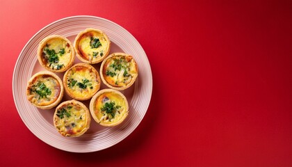 Fototapeta premium Freshly delicious mini quiches on red background