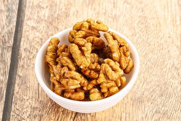 Cracked unshelled walnut in the bowl