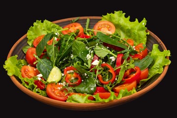 Greek vegetable salad with feta cheese, tomatoes, cucumbers, onions, olive oil on a black background