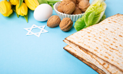 Passover Greeting Card with Matzah, Waluts and Yellow Tulip Flowers on Blue Background.