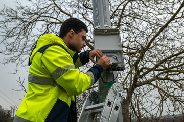 Técnico a trabalhar numa caixa para restabelecer a conexão de rede de fibra ótica aos clientes num dia muito nublado