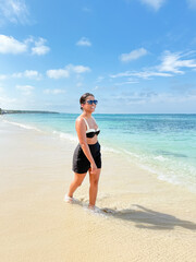Tourist walking on tropical beach enjoying summer vacation