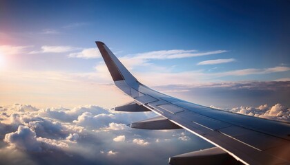 Obraz premium View of a wing of a plane flying above the clouds