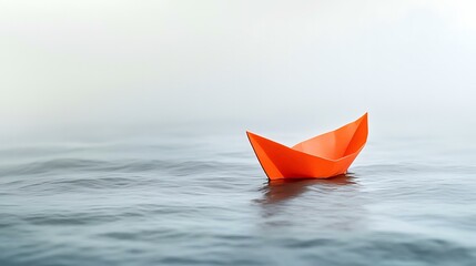 Obraz premium Orange paper boat floats on misty water, hope concept
