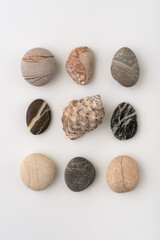 A collection of colorful natural pebbles arranged in rows on a white background