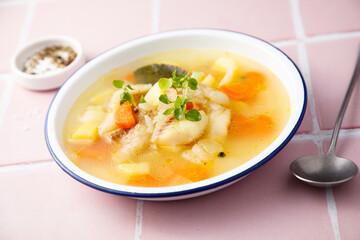 Clear soup with white fish and vegetables