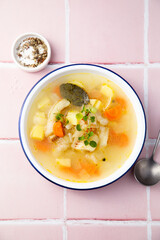 Clear soup with white fish and vegetables