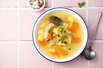 Clear soup with white fish and vegetables