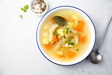 Clear soup with white fish and vegetables