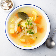 Clear soup with white fish and vegetables