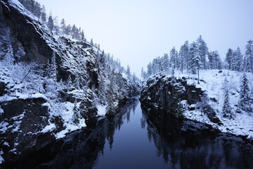 Snowy River Gorge with Frosted Trees and Reflective Water in Winter Landscape