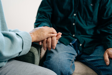 Hands of the old man and a woman hand on the table