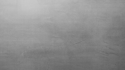 A grey wall with a grey background. The wall is made of concrete and has a rough texture