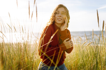 Beauty woman enjoying nature outdoors in tall grass. Calmness and tranquility. Travel, tourism...