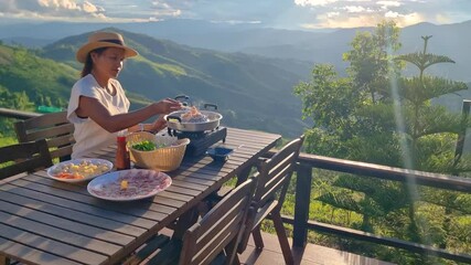 Relaxing in Chiang Mai, a person prepares a delicious feast with breathtaking views of the rice fields and surrounding mountains. This tranquil setting captures the essence of Thai culture and nature.