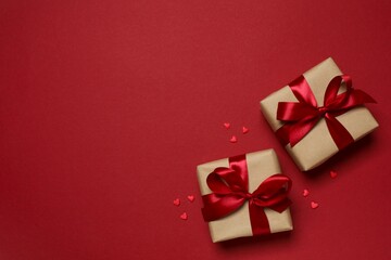Beautiful gift boxes with red hearts on color background