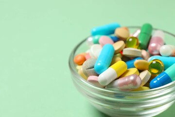 Various pills in a bowl on color background