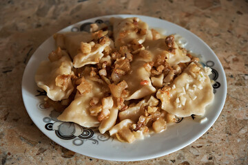 Traditional Ukrainian dish, potato dumplings with cracklings. Selective focus