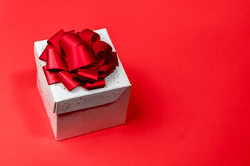 White gift box in red background. Elegant white gift box with red ribbon. Flat lay.
