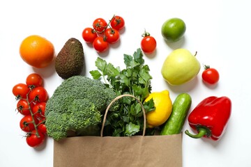 Paper bag, vegetables and fruits on color background, space for text