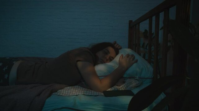 Insomnia, sleeplessness. Weary young woman is unable to sleep at night.