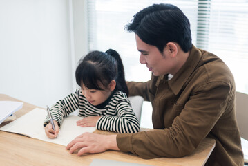 Obraz premium Young Asian father and daughter studying together