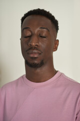 Obraz premium Young African man standing alone with his eyes closed