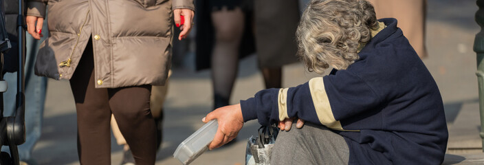 Beggar old woman begging for money on the street