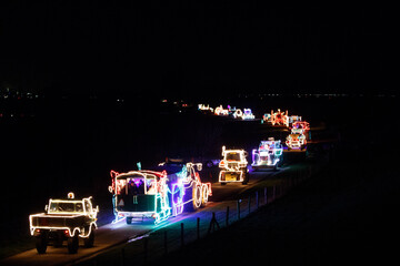 Obraz premium Celebration of illuminated agricultural vehicles parading through the polder at night
