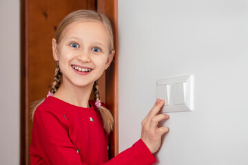 Turning off Light Switch.  Little Girl Child Turns off the Light, Learning Good Habits. Conserve...