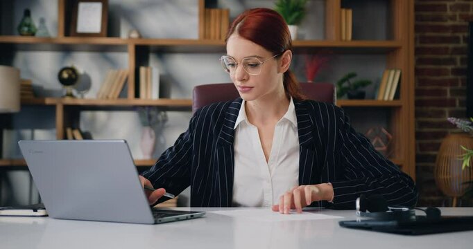 Woman using a laptop program calculates expenses, income, estimates project budget, accountant conducts financial audit, summarizes the total amount at modern office