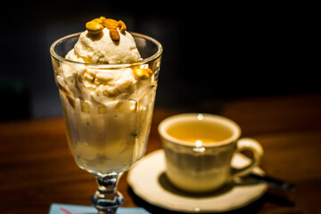 ice cream served with toasted peanuts on top and in  tall glass