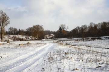 Fototapeta premium Winter rural landscape. Winter road and trees covered with snow. Beautiful view of a small village in western Ukraine.