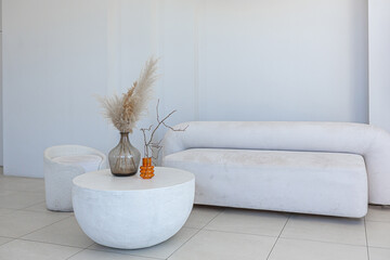 modern pure white interior design of a sprsious sitting room with soft stylish furniture. Large...