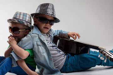Two young musicians playing harmonica and guitar, wearing hats a