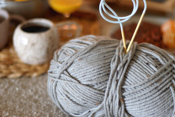 Books, e-reader, tea, orange juice, fruit, snacks, yarn, blanket and lit candles on the table....
