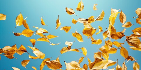 Naklejka premium Golden Leaf Dance: Autumn leaves swirl and dance against a vibrant blue sky, creating a mesmerizing ballet of color and motion.
