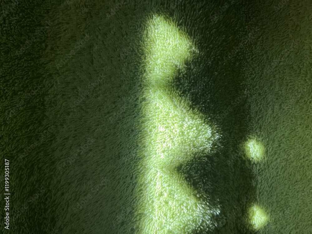 Aufkleber subtle sunlight creating geometric patterns on textured green towel fabric, perfect for abstract designs, background concepts, or natural themes