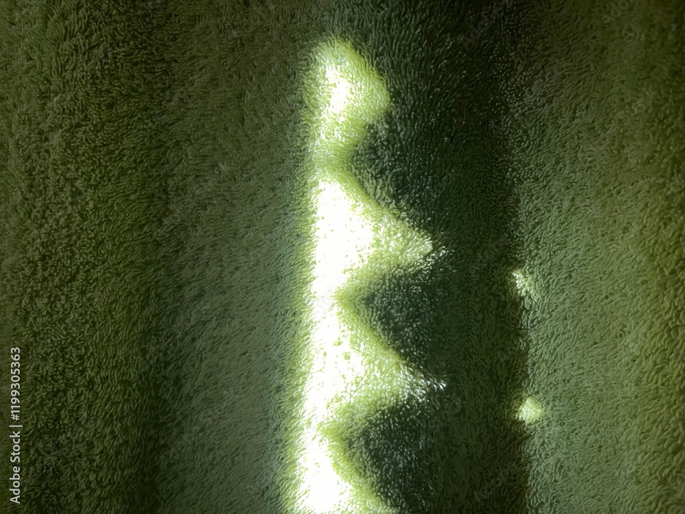 Poster subtle sunlight creating geometric patterns on textured green towel fabric, perfect for abstract des
