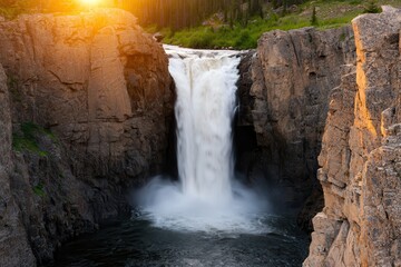 Run-down landscapes in a national park Majestic waterfall cascading between rocky cliffs at sunset.