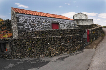 Traditional stone houses built from black volcanic rock on Azores, Pico island