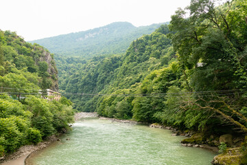 mountainous landscape in Georgia with overgrown green cliffs of the Caucasus Mountains in summer