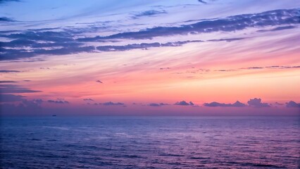 Fototapeta premium Beautiful sunset over a calm ocean with vibrant gradient colors and serene clouds for landscape and nature themes