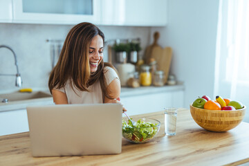Woman Enjoying Healthy Salad While Working Remotely on Laptop at Home