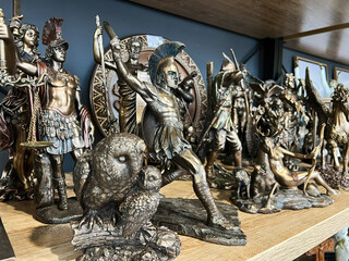 Collection of detailed figurines inspired by Greek mythology displayed on a wooden shelf