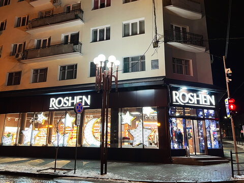Kyiv, Ukraine - January 16, 2025: Night view of a lit-up Roshen storefront on a city street corner