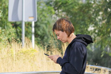Fototapeta premium Portrait of a woman looking attentively and intently at the smartphone screen.