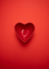 Heart-shaped plate on a rich red background, symbolizing love and romance. Perfect for Valentine's Day, weddings, anniversaries, and romantic celebrations. Ideal for festive decor and gifts