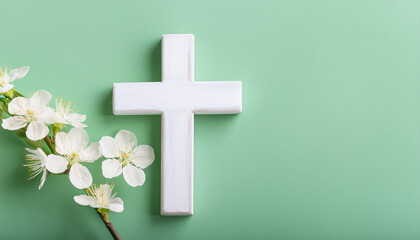 Obraz premium Wooden cross and spring flowers on pastel green background. Happy Easter. Religion and faith